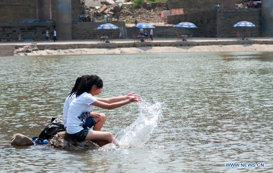 Girls cool themselves off in the Jialingjiang River at Ciqikou Town in Chongqing, southwest China's municipality, June 16, 2013. 