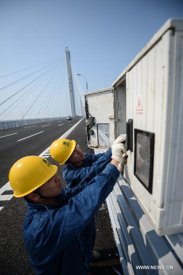 Electricians work on the Jiaxing-Shaoxing Sea Bridge in Shaoxing, east China's Zhejiang Province, June 17, 2013. 