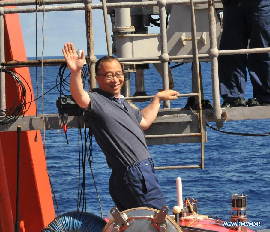 Zhou Huaiyang, professor of the School of Ocean and Earth Science at Tongji University, waves before entering China's manned deep-sea submersible Jiaolong aboard the Xiangyanghong 09 in South China Sea, June 18, 2013. 