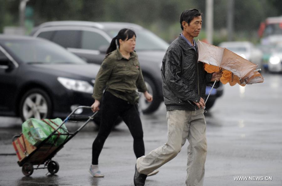 Citizens walk in the rain in Yinchuan, capital of northwest China's Ningxia Hui Autonomous Region, June 19, 2013. 