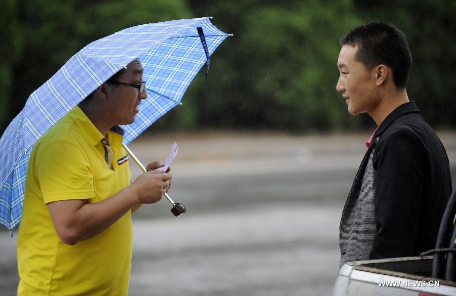A citizen holding an umbrella is seen in the rain in Yinchuan, capital of northwest China's Ningxia Hui Autonomous Region, June 19, 2013. 