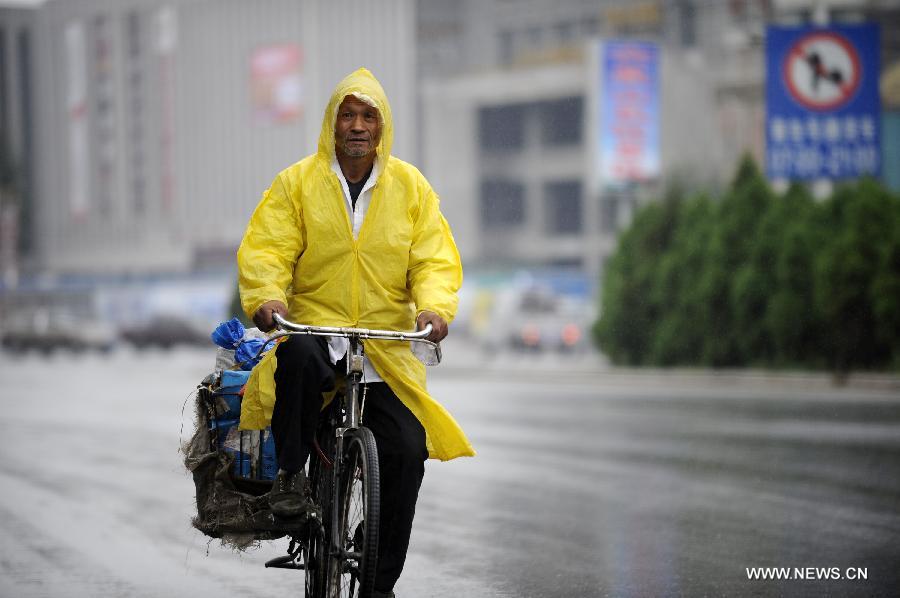 A citizen rides a bicycle in the rain in Yinchuan, capital of northwest China's Ningxia Hui Autonomous Region, June 19, 2013.