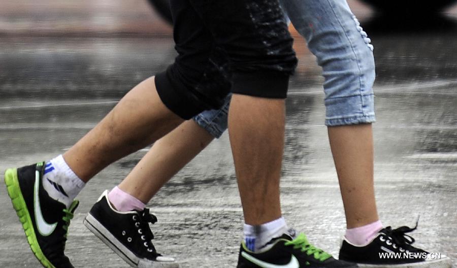 Citizens walk in the rain in Yinchuan, capital of northwest China's Ningxia Hui Autonomous Region, June 19, 2013. 
