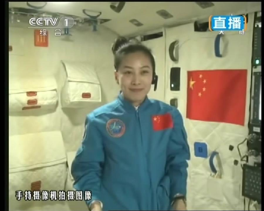 This TV grab taken on June 20, 2013 shows female astronaut Wang Yaping (R), one of the three crew members of Shenzhou-10 spacecraft, giving a lecture to students on Earth aboard China's space module Tiangong-1. 