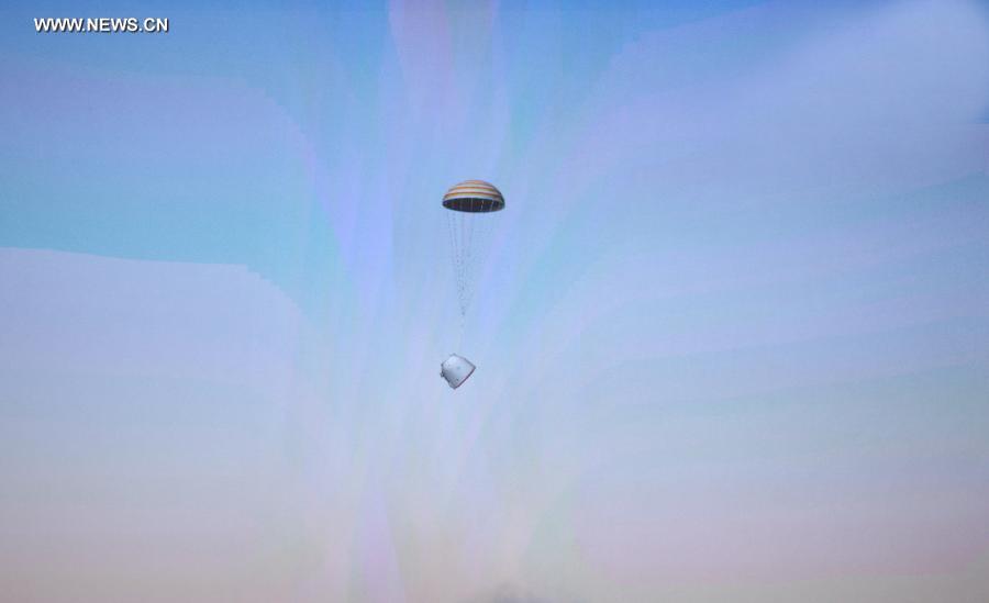 The screen at the Beijing Aerospace Control Center shows the landing of the re-entry capsule of China's Shenzhou-10 spacecraft during its return to the earth on June 26, 2013.