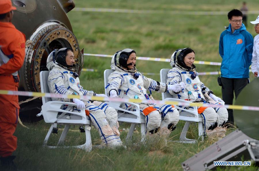 Astronauts Zhang Xiaoguang, Nie Haisheng and Wang Yaping (from left to right) pose after getting out of the re-entry capsule of China's Shenzhou-10 spacecraft following its successful landing at the main landing site in north China's Inner Mongolia Autonomous Region on June 26, 2013.