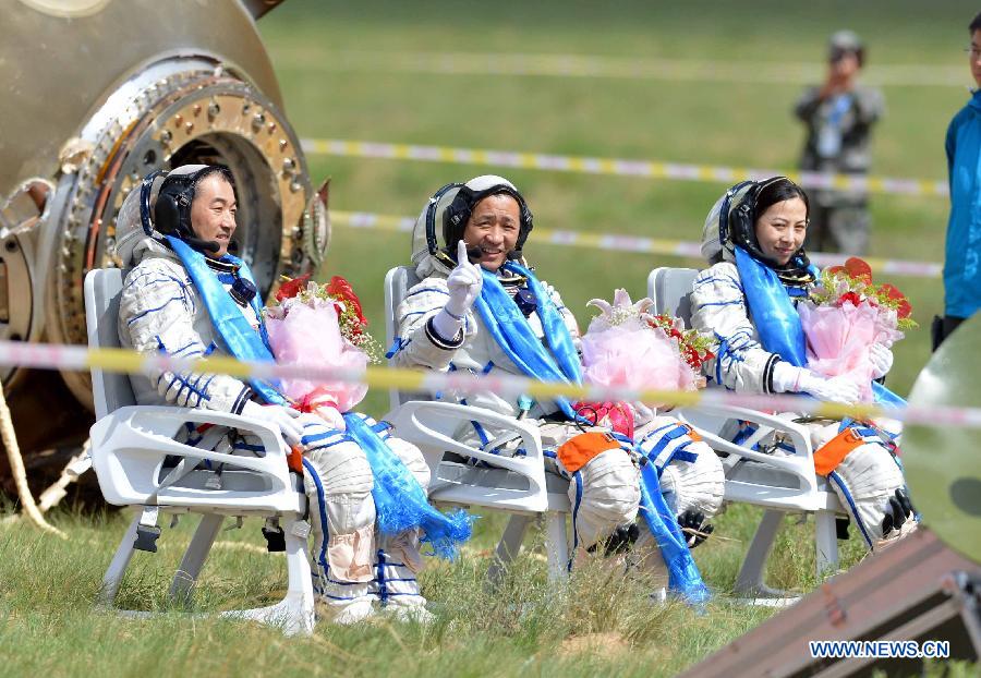 Astronauts Zhang Xiaoguang, Nie Haisheng and Wang Yaping (from left to right) pose after getting out of the re-entry capsule of China's Shenzhou-10 spacecraft following its successful landing at the main landing site in north China's Inner Mongolia Autonomous Region on June 26, 2013.