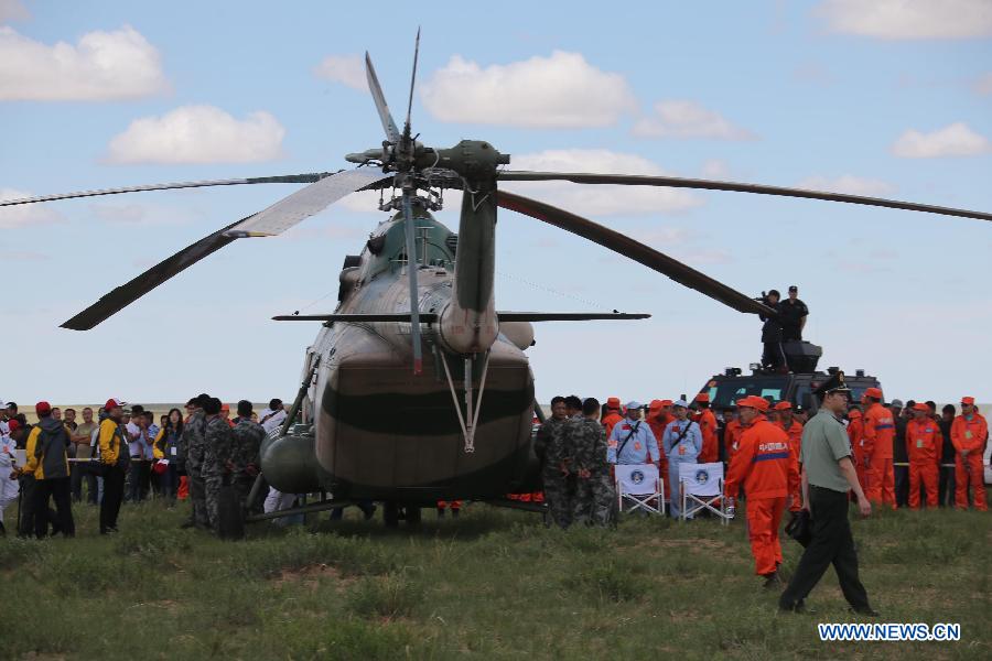 Astronauts are escorted to board a helicopter for medical care after getting out of the re-entry capsule of China's Shenzhou-10 spacecraft following its successful landing at the main landing site in north China's Inner Mongolia Autonomous Region on June 26, 2013. 
