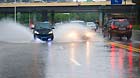 Vehicles run on a waterlogged road in rain in Nanchang, capital of east China's Jiangxi Province, June 28, 2013.