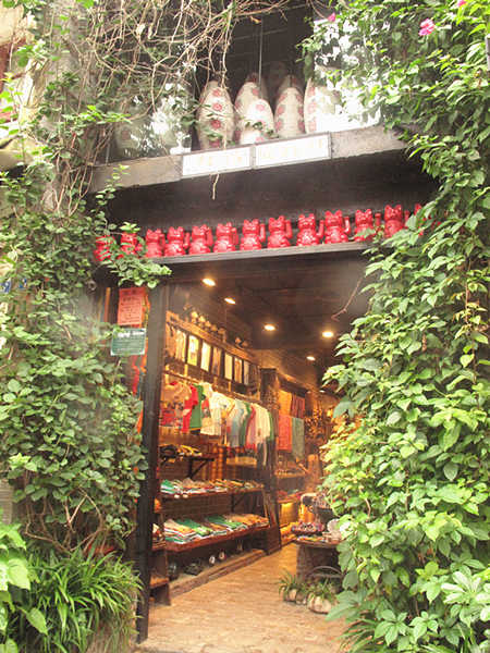 This photo taken on June 28th shows a garment shop in West Street in Yangshuo County of Guangxi Zhuang Autonomous Region. With a history of over 1,400 years, West Street is located in the center of Yangshuo County and is also called Foreigner's Street. Here, the bars, hotels, Internet cafes and painting shops' decoration style is mostly Chinese mixed with Western culture. [CnDG by Jiao Meng]