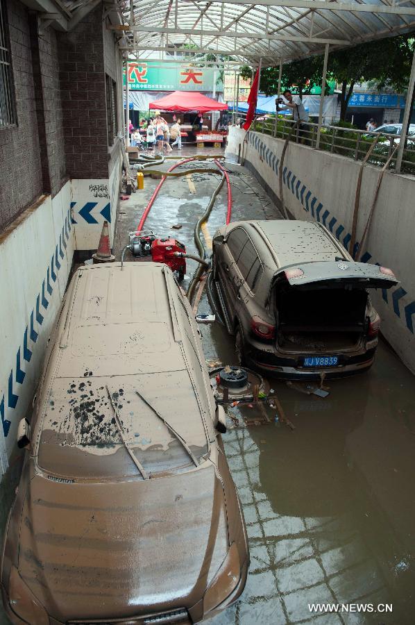 Vehivles park at the entrance to a flooded underground parking lot in Suining, southwest China's Sichuan Province, July 2, 2013. 