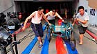 Residents push a tricycle out of a flooded underground parking lot in Suining, southwest China's Sichuan Province, July 2, 2013.