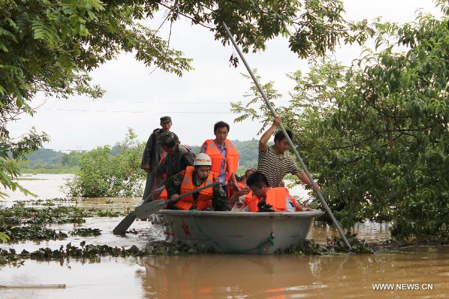 Rescuers row a boat heading for the flooded Hebei Village, Qingyang County, east China's Anhui Province, July 6, 2013. 