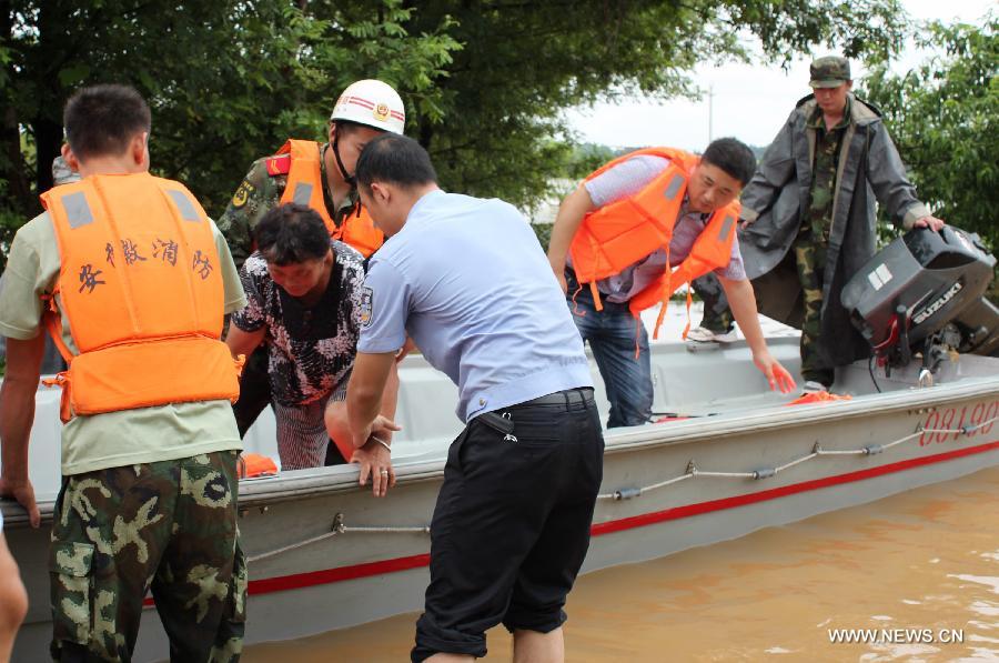 Rescuers evacuate a woman stranded by floods in Hebei Village, Qingyang County, east China's Anhui Province, July 6, 2013. 