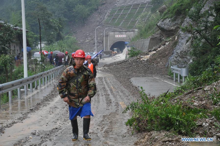 Communication emergency workers walk into rainstorm-hit Beichuan Qiang Autonomous County, southwest China's Sichuan Province, July 9, 2013. 