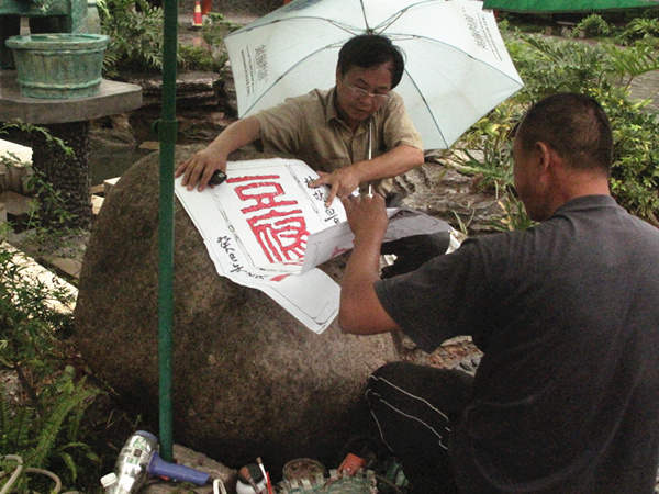 Two workers try to carve characters onto the stone. [CnDG by Jiao Meng]