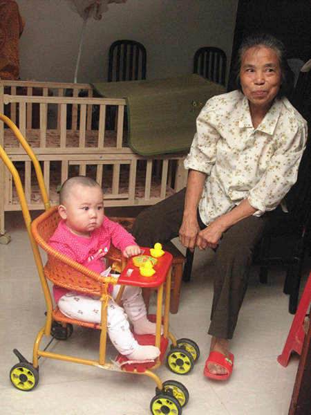 A grandma takes cares of her grandchild in Lujia New Village. [CnDG by Jiao Meng]