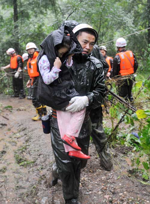A child is evacuated from the landslide site in Zhongxing, a town in Dujiangyan, Sichuan Province, on Wednesday. At least two people were killed. A child is evacuated from the landslide site in Zhongxing, a town in Dujiangyan, Sichuan Province, on Wednesday. At least two people were killed.