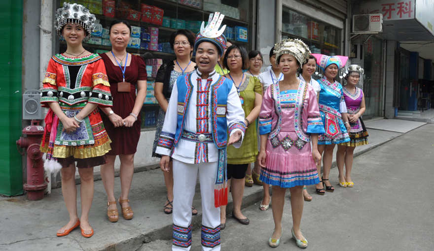 Local residents wearing traditional national costumes sing folk songs to welcome visitors at the Dalongtan Community of Liuzhou City, south China's Guangxi Zhuang autonomous region.