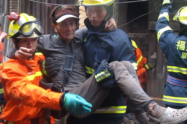 A man is rescued from a house that collapsed on Sunday after Typhoon Soulik dumped 240 mm of rain in the Tongan District of Xiamen, Fujian Province.