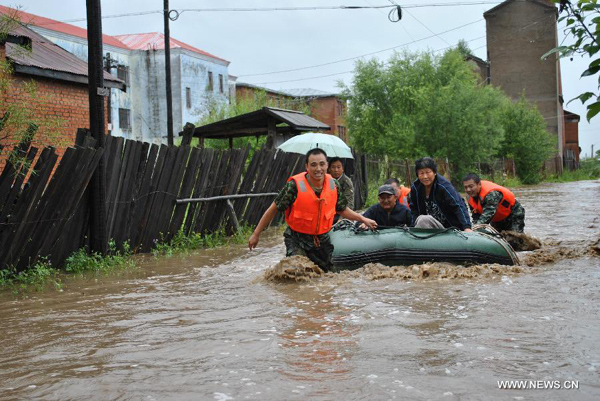 Rescuers transfer trapped residents in flood-hit Genhe City, Hulun Buir, north China's Inner Mongolia Autonomous Region, July 28, 2013. Rainstorm-triggered flood hit the city on Sunday.