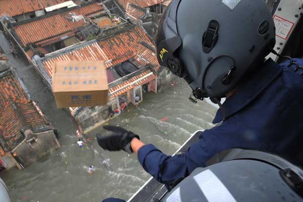 Rescue workers drop relief supplies such as food and water on Wednesday in Shantou, Guangdong Province, which was severely affected by flooding.