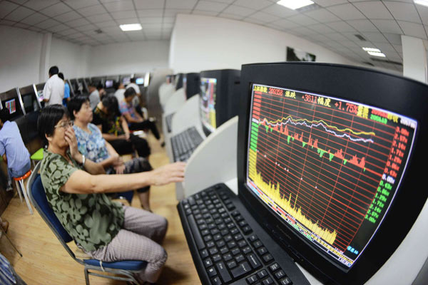Investors conduct stock transactions at a brokerage office in Qingdao, Shandong Province. An optimistic economic outlook and upbeat data helped push the benchmark Shanghai Composite Index up 1.9 percent to close at 2,096.74 points on Monday. 