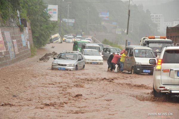 Vehicles are stranded on a landslides-hit road in Yiliang County, southwest China's Yunnan Province, Aug. 25, 2013. Rainstorms-triggered mountain floods, landslides and mud-rock flows hit the county in this weekend.