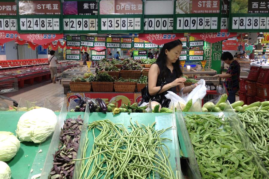 A citizen selects vegetables at a supermarket in Shanghai, east China, Sept. 8, 2013. China&apos;s consumer price index, a main gauge of inflation, rose 2.6 percent year on year in August, down from 2.7 percent in July, the National Bureau of Statistics (NBS) said on Monday. 