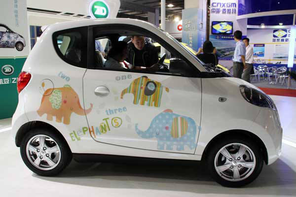 Customers examine an electric car at an exhibition in Beijing on Saturday. The government plans to have at least 10,000 new-energy vehicles sold between 2013 and 2015 in each of the country's megacities, according to the guideline for the electric vehicle industry.