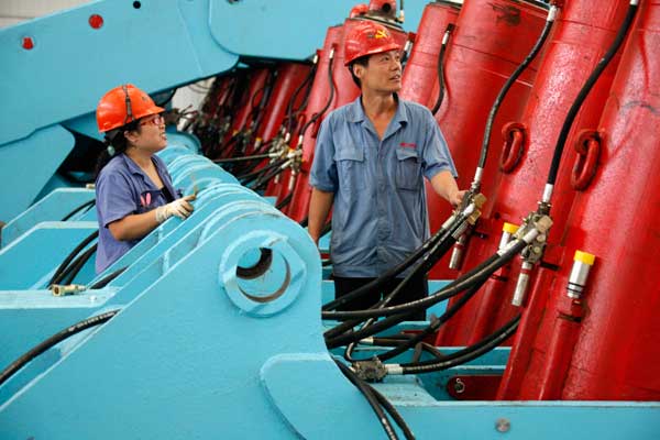 Workers examine mining equipment on Monday in Huaibei, Anhui Province. HSBC's preliminary PMI reading for September, which is at 51.2, boosted confidence that the government's annual growth target could be met.