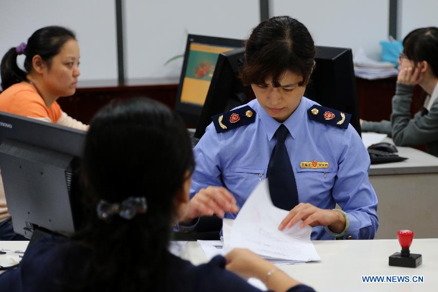 An officer deals with the application in the service hall of the free trade zone (FTZ), east China&apos;s Shanghai, Oct. 8, 2013. 