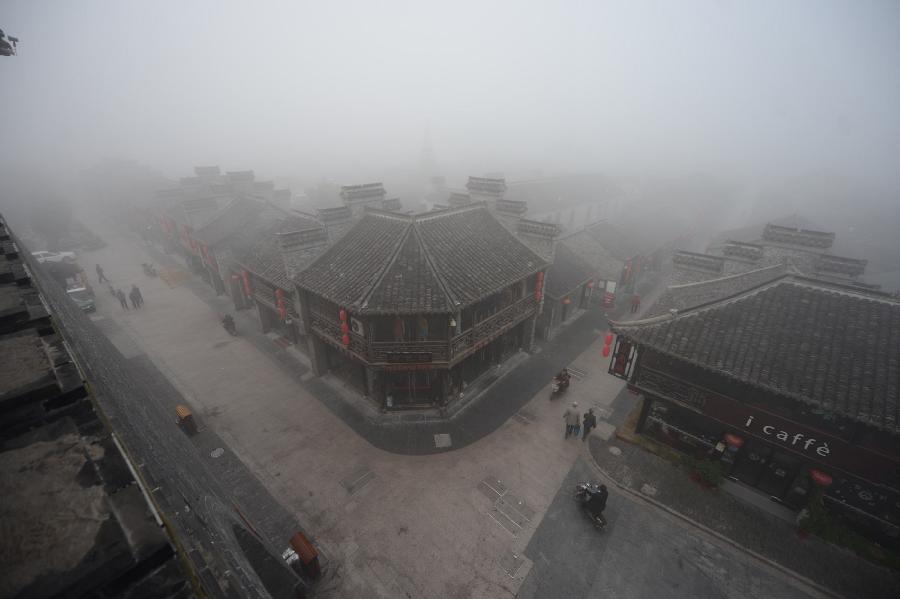 Photo taken on Oct. 20, 2013 shows the Dongguan Street shrouded in heavy fog in Yangzhou City, east China&apos;s Jiangsu Province. A heavy fog hit Yangzhou on Sunday. 