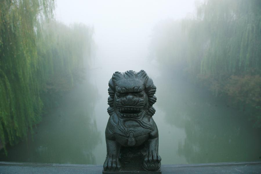 Photo taken on Oct. 20, 2013 shows a river shrouded in heavy fog in Yangzhou City, east China&apos;s Jiangsu Province. 