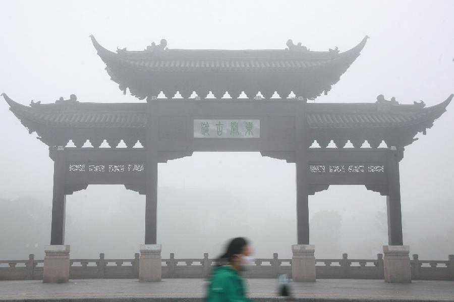 A woman rides bicycle in heavy fog in Yangzhou City, east China&apos;s Jiangsu Province, Oct. 20, 2013. 