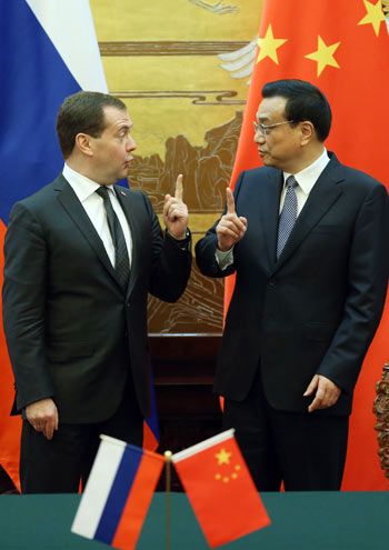 Premier Li Keqiang and his Russian counterpart Dmitry Medvedev share a light moment at a signing ceremony in Beijing on Tuesday.