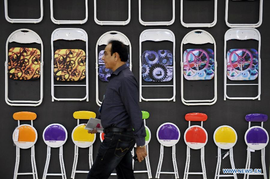 A foreign purchaser walks past a pavilion in the Canton Fair in Guangzhou, capital of south China&apos;s Guangdong Province Oct. 23, 2013.