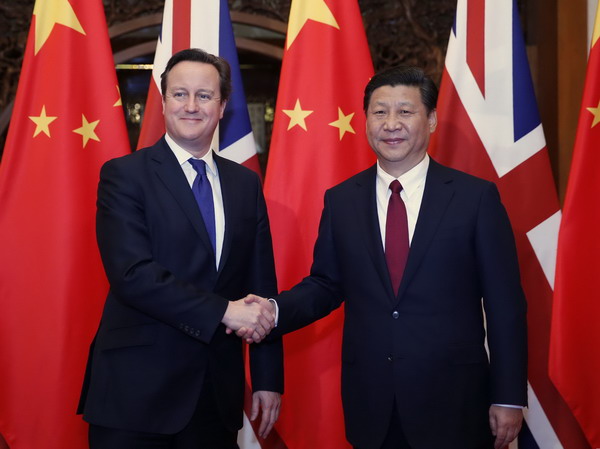Chinese President Xi Jinping shakes hands with visting British Prime Minister David Cameron in Beijing on Monday.