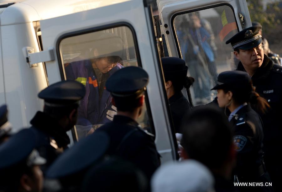Zhang Shuxia, who is involved in a baby trafficking scandal, is escorted to the Weinan Intermediate People's Court for a trial in Weinan, northwest China's Shaanxi Province, Dec. 30, 2013. Zhang was a doctor with the Fuping County Maternal and Child Health Care Hospital in the province and was detained by police in connection with trafficking of babies in August. (Xinhua/Li Yibo)