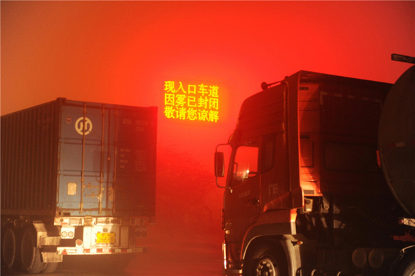 A digital sign reading 'the highway closed due to the haze' is seen near the entrance to Wuqiang county, Hengshui city of North China's Hebei province, on Shijiazhuang-Cangzhou Expressway, on the evening of Dec 7. Hebei province raised its smog alert to red on Dec 6, the highest level in the three-tier color-coded warning system. [Photo/Xinhua]