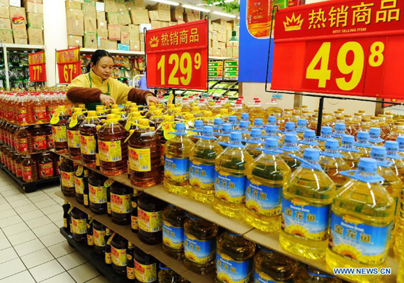 A seller arranges cooking oil at a supermarket in Shijiazhuang, capital of north China's Hebei Province, Jan. 8, 2013. 