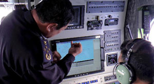Members of Malaysian Maritime Enforcement Agency discuss when searching for the missing flight of Malaysian Airlines, March 9, 2014.