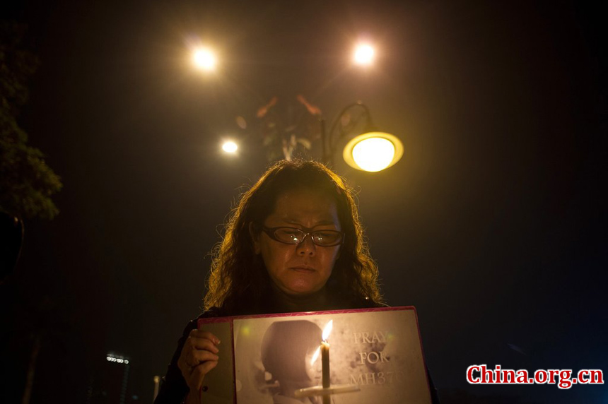 A Malaysian ethnic Chinese woman takes part in a vigil for missing Malaysia Airlines passengers at the Independence Square in Kuala Lumpur on March 10, 2014.