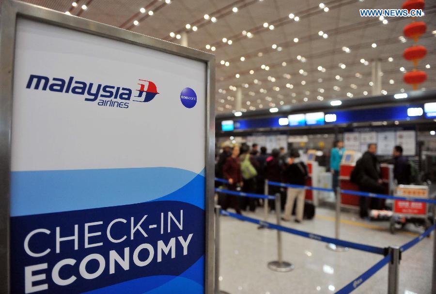 Staff members of Malaysia Airlines and volunteers accompanying relatives of passengers aboard the airlines' missing flight MH370 are seen at Terminal 3 of Capital International Airport in Beijing, capital of China, early March 11, 2014. Some of the relatives of passengers aboard the missing Malaysia Airlines flight MH370 left Beijing for Kuala Lumpur early on Tuesday. [Xinhua] 