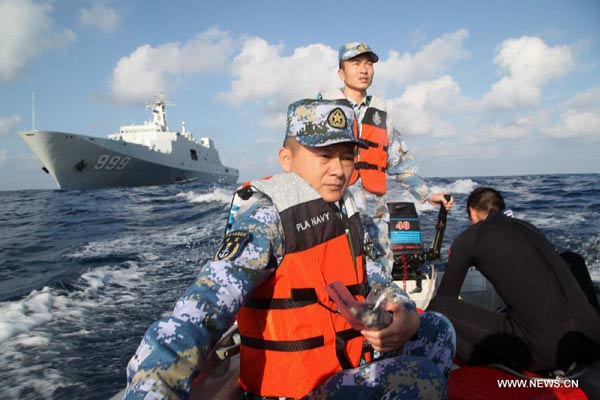  Rescuers aboard the Chinese naval vessel Jianggangshan take a boat to carry out search mission at the possible crash site of missing Malaysia Airlines flight MH370, March 13, 2014. As of 12 a.m. (0400 GMT) Thursday, Chinese search teams had searched 45,763 square kilometers, no solid clues were located. [Xinhua]
