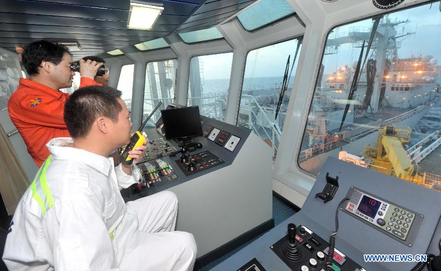 Captain of the Chinese rescue vessel 'Nanhaijiu 101' Yu Zhige and vice commander Zhang Jianxin direct the ship to approach Qiandaohu comprehensive supply ship, as both of them head toward Singapore to join in the search for missing Malaysia Airlines flight MH370, March 18, 2014. At 8:00 a.m. on Tuesday, China's Ministry of Transportation ordered all Chinese vessels in the Gulf of Thailand to leave for searches in the waters southeast of the Bay of Bengal and near the Sunda Strait. 