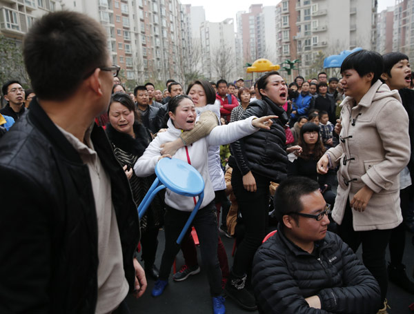 Angry parents come to a private kindergarten in Xi’an on Tuesday to demand an explanation about drugs they say were given to their children. The local government sent a team to the kindergarten to investigate. [Photo/China Daily]