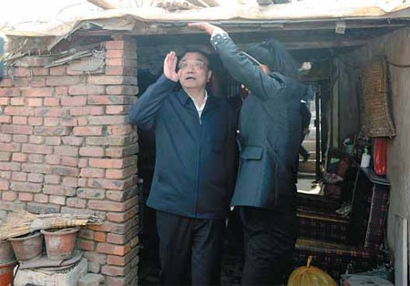 Premier Li Keqiang checks the ceiling of a resident's home in Tienan, a shantytown in Chifeng, Inner Mongolia autonomous region, on Thursday. 