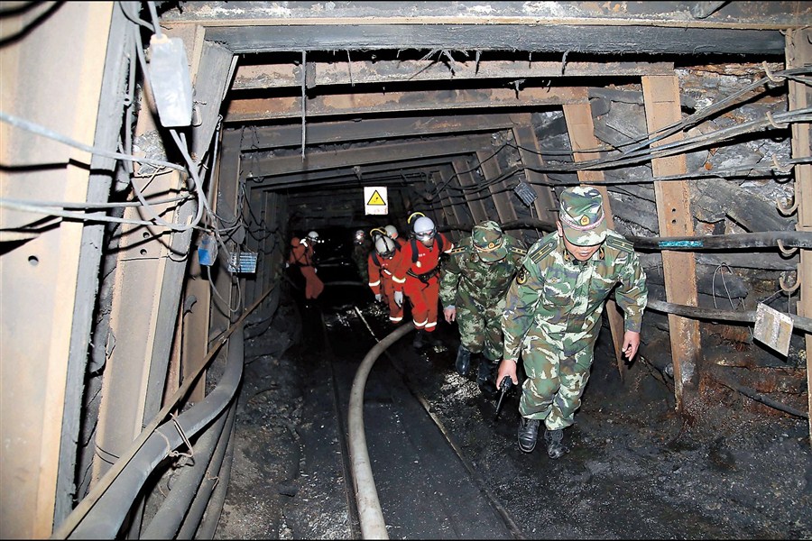 Rescuers head into the coal mine in southwest China’s Yunnan Province where 22 people remain trapped. The shaft in which they were working flooded early yesterday morning.