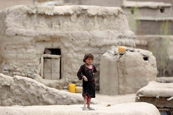 An Afghan child stands outside after a landslide in Badakhshan Province of northern Afghanistan on May 3, 2014. Up to 255 victims were identified out of hundreds of villagers buried under their collapsed houses in a deadly landslide Friday in Badakhshan, a provincial disaster official said Saturday. [Photo/Xinhua]